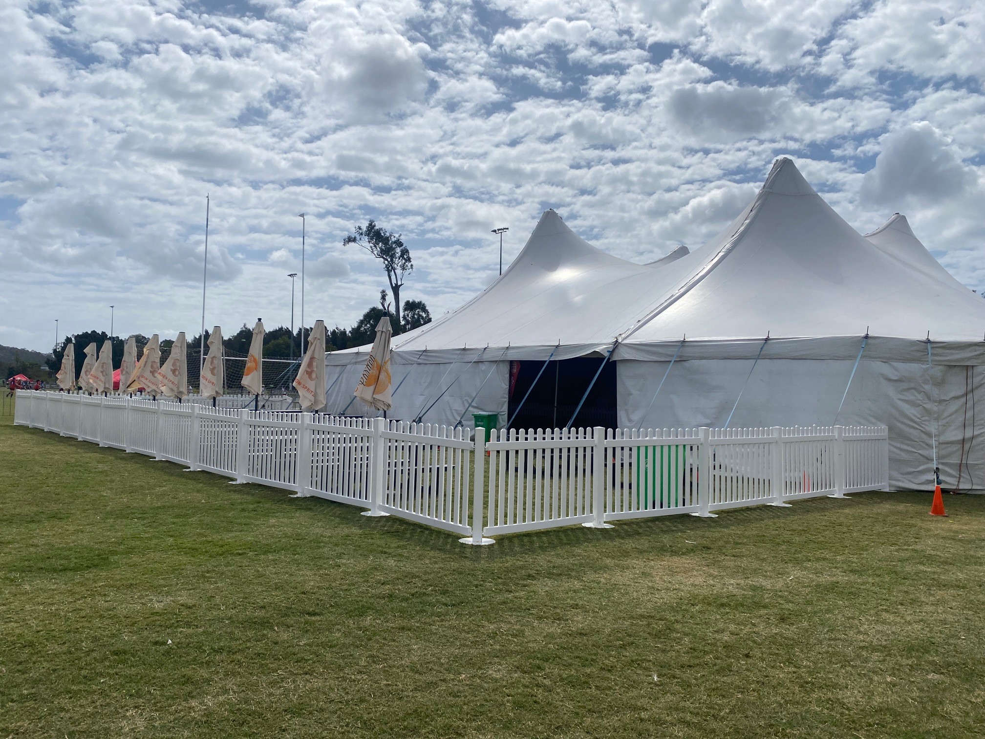 A 26 metre structure with picket fencing and umbrellas on a sports field