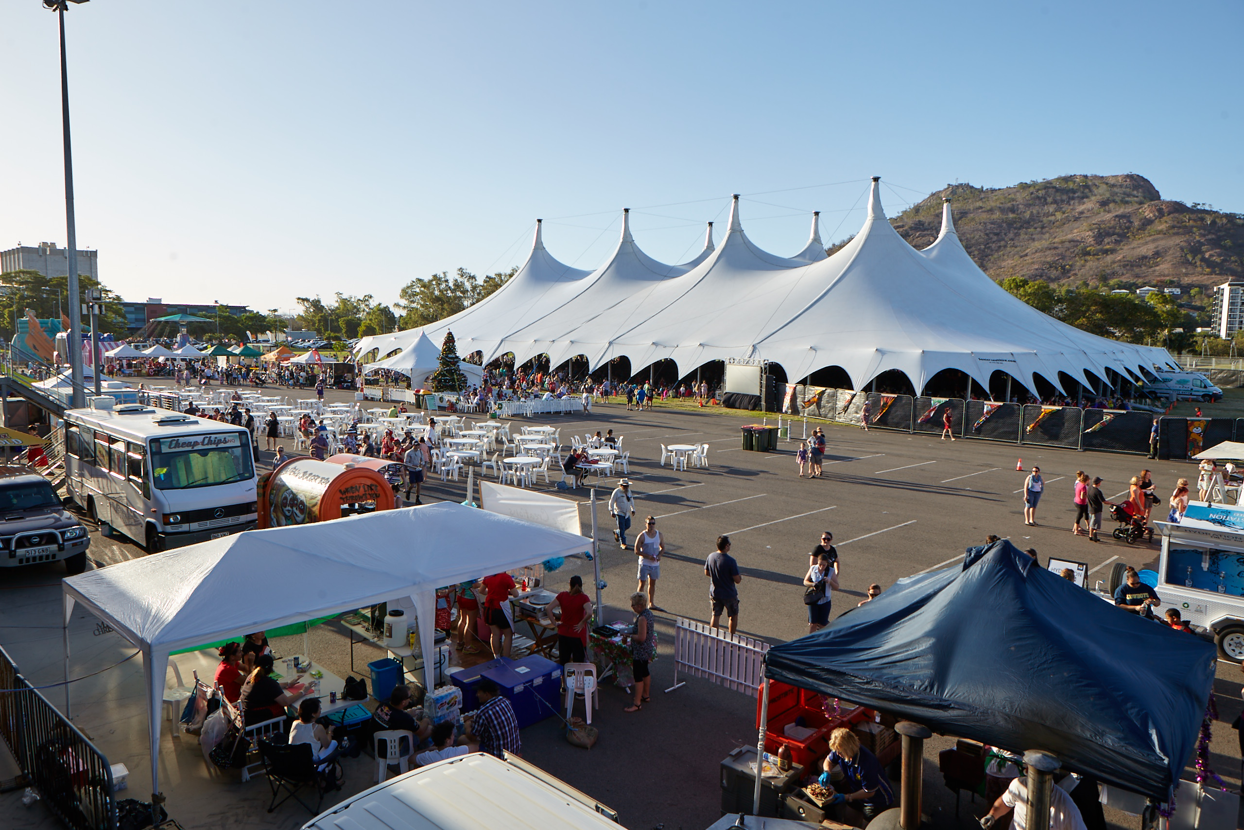 A Majestic event tent at a public festival with food stalls and crowds